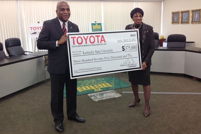Toyota Motor Manufacturing Kentucky President Wil James (left) presents Dr. Mary Sias, president of Kentucky State University, with a $375,000 check to establish the Toyota Engineering Scholarship on March 18, 2014.