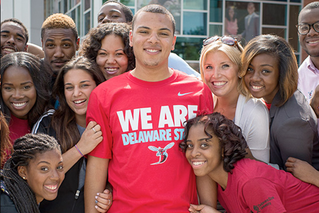A group of Delaware State students and faculty pose on DSU's campus.