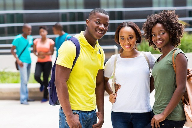 A group of smiling African American students pose during their HBCU campus visit.