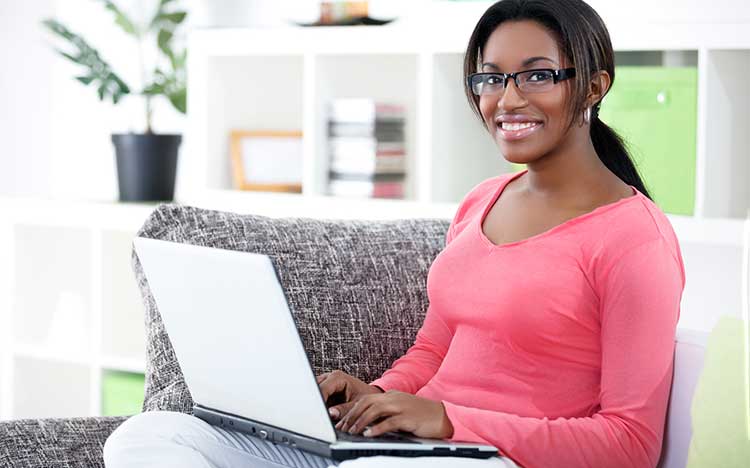 African-American female student uses a laptop to search for black college resources.