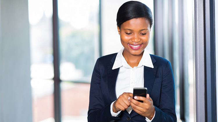 Smiling African-American law student using legal app on her smart phone.