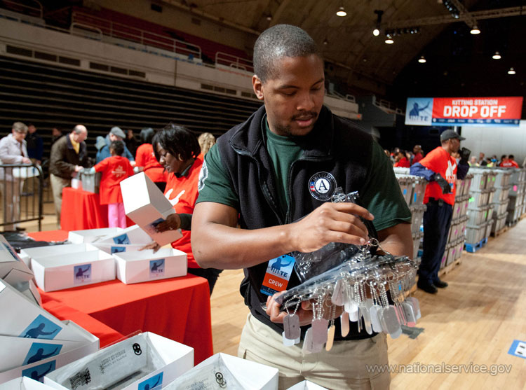 An AmeriCorps member prepares items to pack in kits for overseas troops at the DC Armory during 2013 National Day of Service and MLK Day activities.