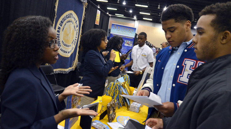 A representative at the Southern University and A&M College booth speaks with high schools students at the 2015 Atlanta Black College Expo.