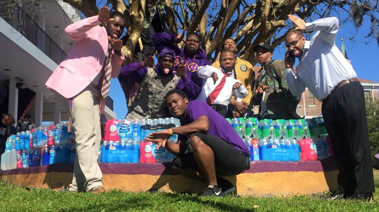 Members of the Chi Chapter of the Omega Psi Phi Fraternity, Inc. at Edward Waters College with water supllies
