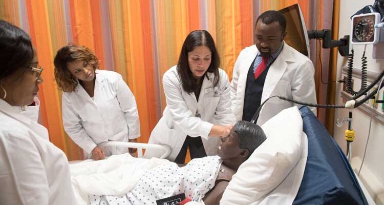 Bowie State's nursing program students check a patient in class simulation.